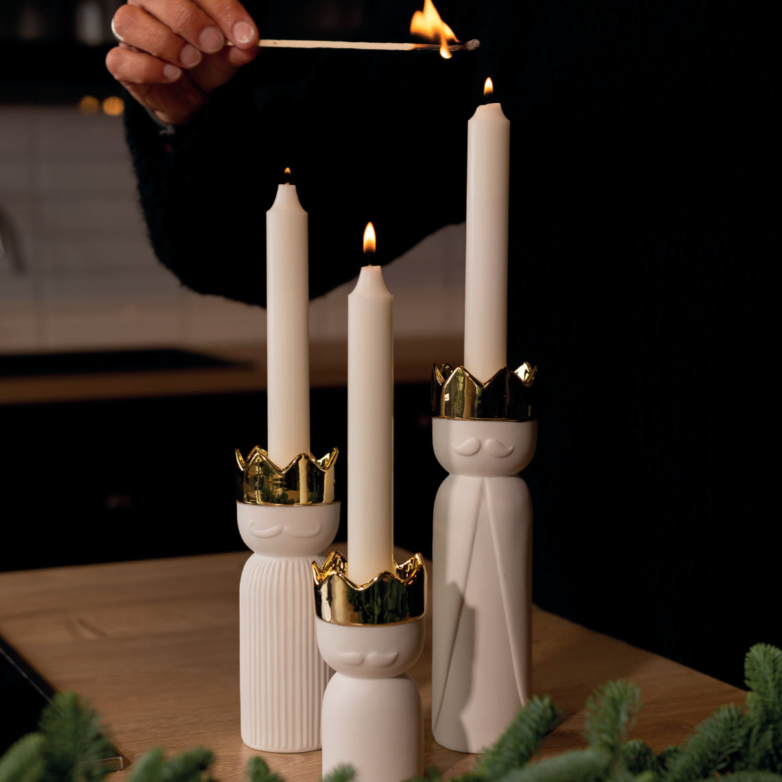 Trio de bougeoirs en forme de roi mage en porcelaine avec leur couronne dorée.