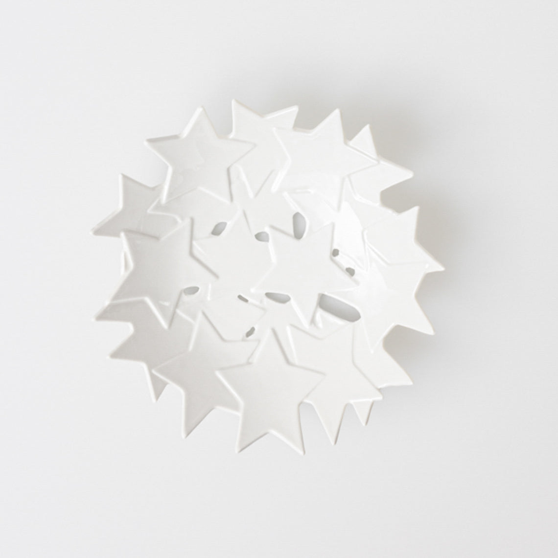 Coupe en porcelaine émaillée, formée par une constellation d’étoiles en léger relief assemblées entre elles.