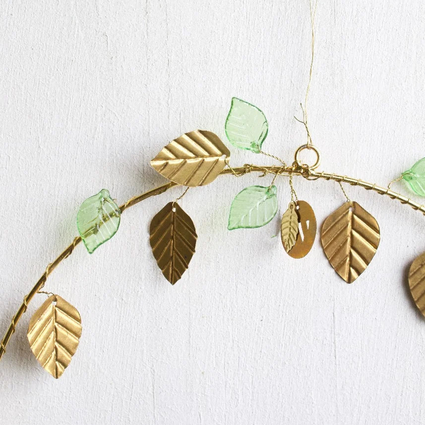 Couronne en fils dorés avec des feuilles dorées et vertes, à poser ou à suspendre en décoration de Noël.