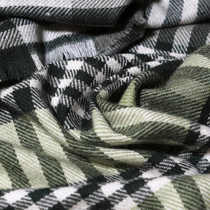 Echarpe en laine à motifs écossais dans les tons verts foncés et noirs.