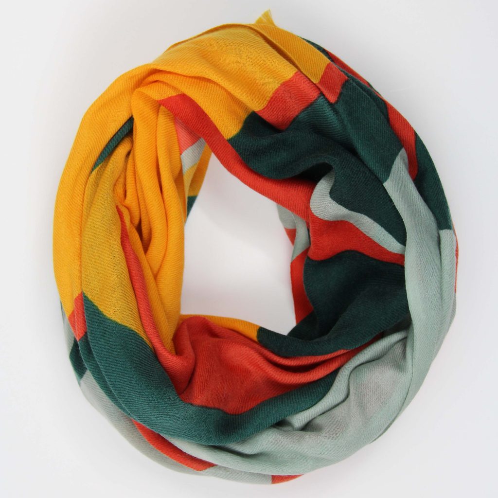 Echarpe en laine roulée avec le dessin Palme orange : un motif graphique et végétal dans les tons bleu pâle, jaune, orange et vert sapin.