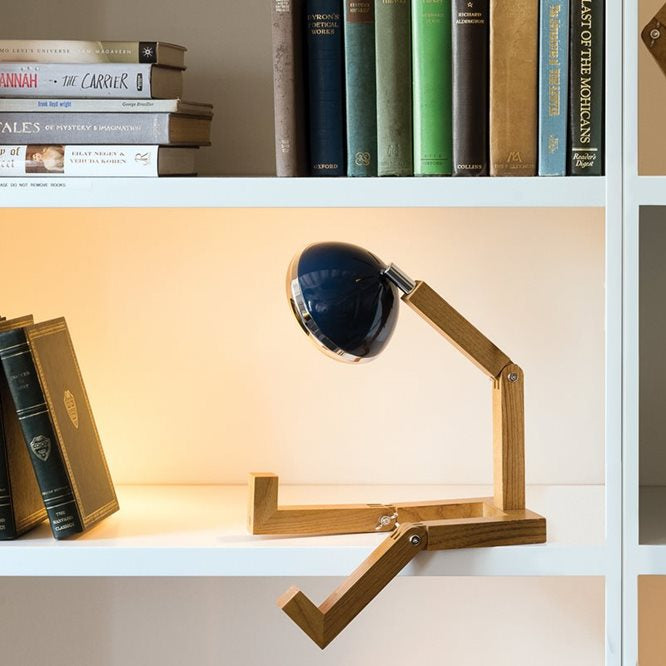 Lampe à poser en forme de bonhomme articulé avec un phare à la place de la tête, coloris bleu.
