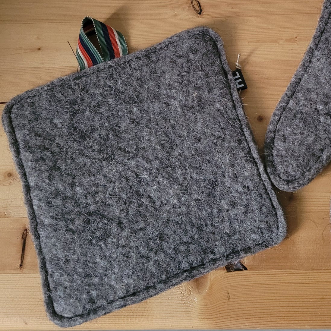 Manique carrée en laine feutrée française, coloris gris foncé.