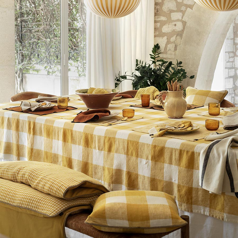 Nappe à grands carreaux, modèle Palma Jaune Paille de chez Haomy posée sur une table.