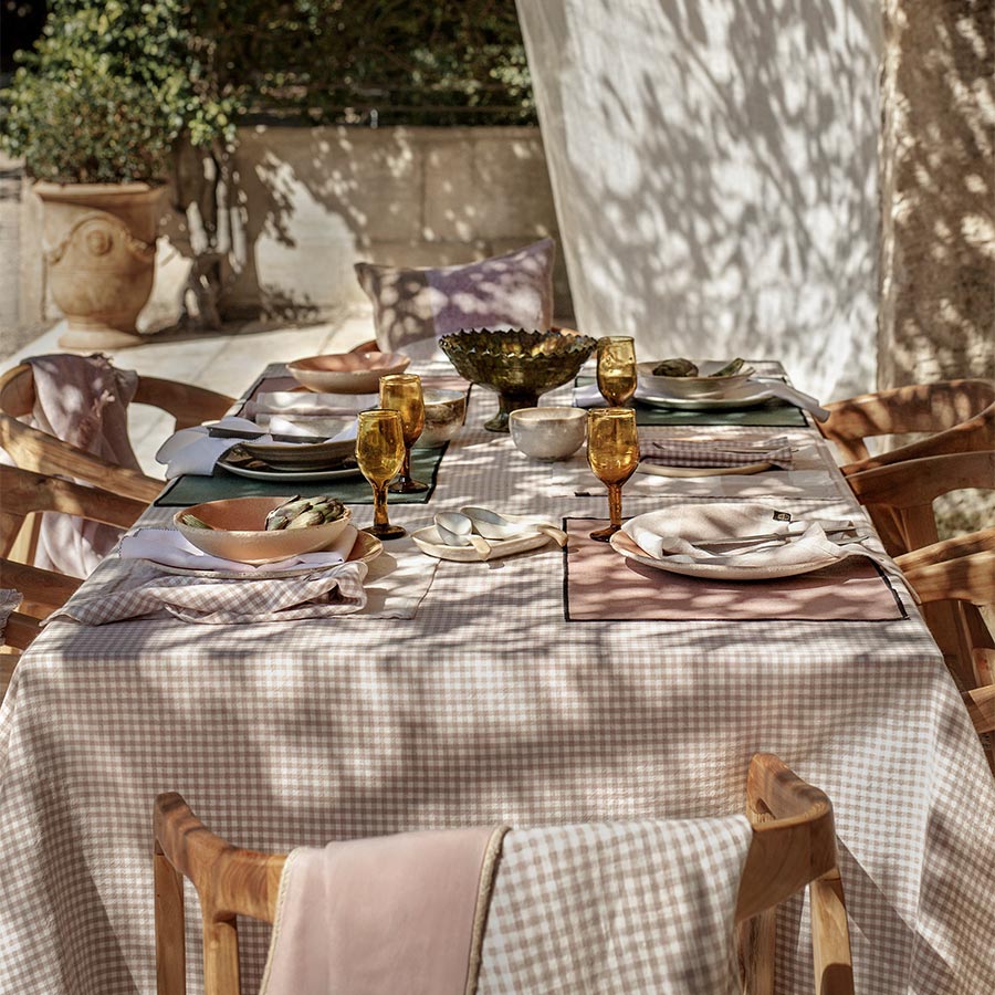 Nappe à petits carreaux, style vichy, modèle Piana Pétale de chez Haomy posée sur une table.