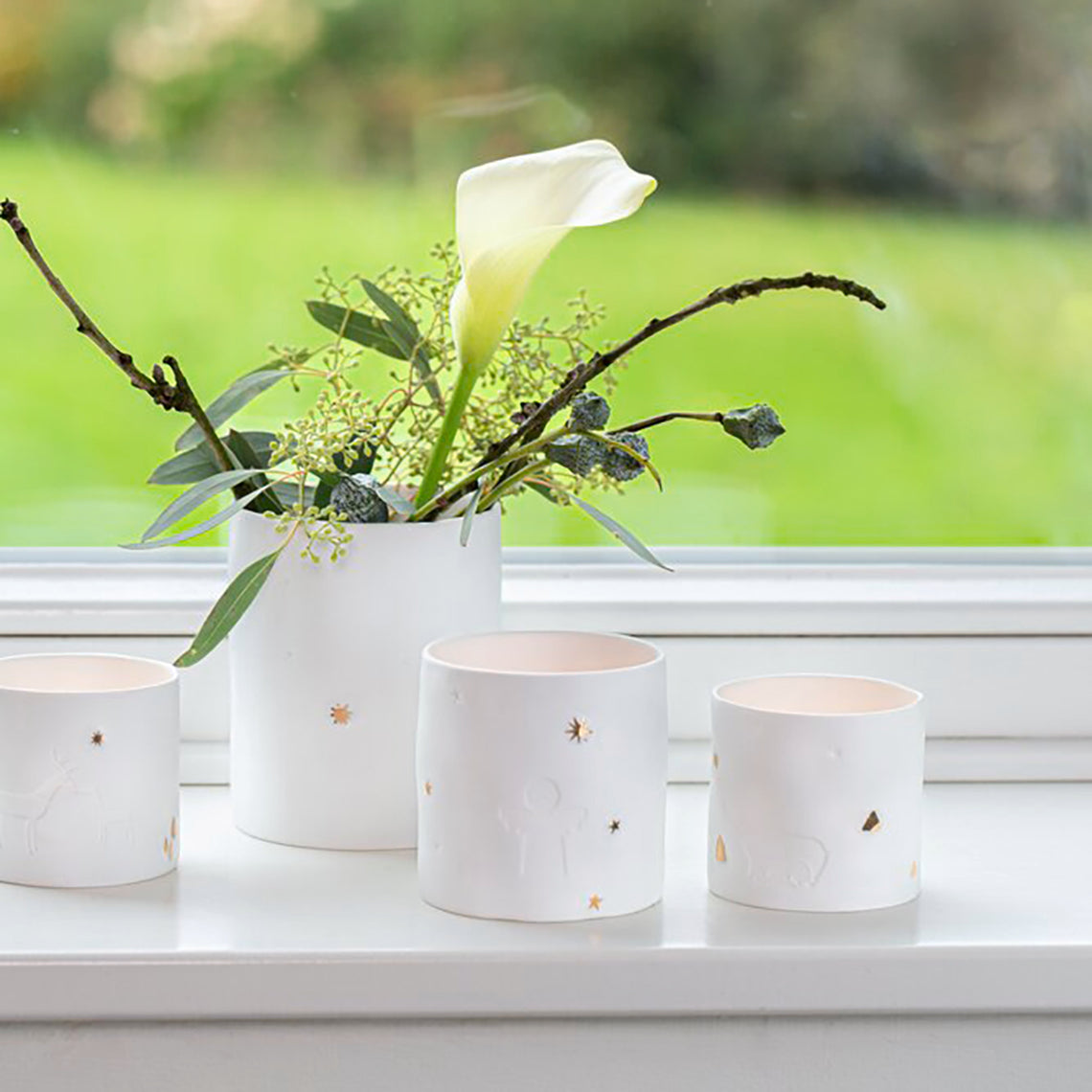 Photophores ronds en porcelaine avec détails gaufrés et dorés.
