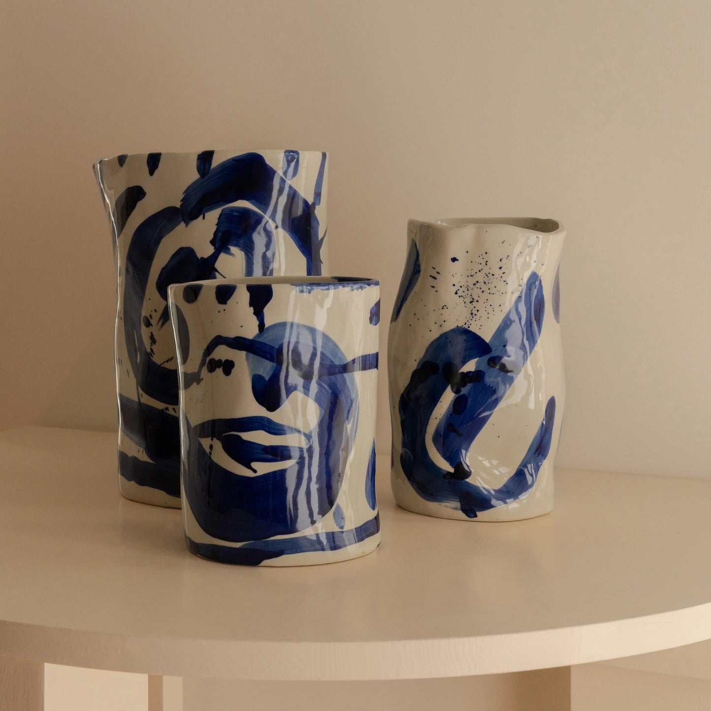 Trio de vases en céramique à la forme irrégulière et peint à la main dans un bleu indigo.