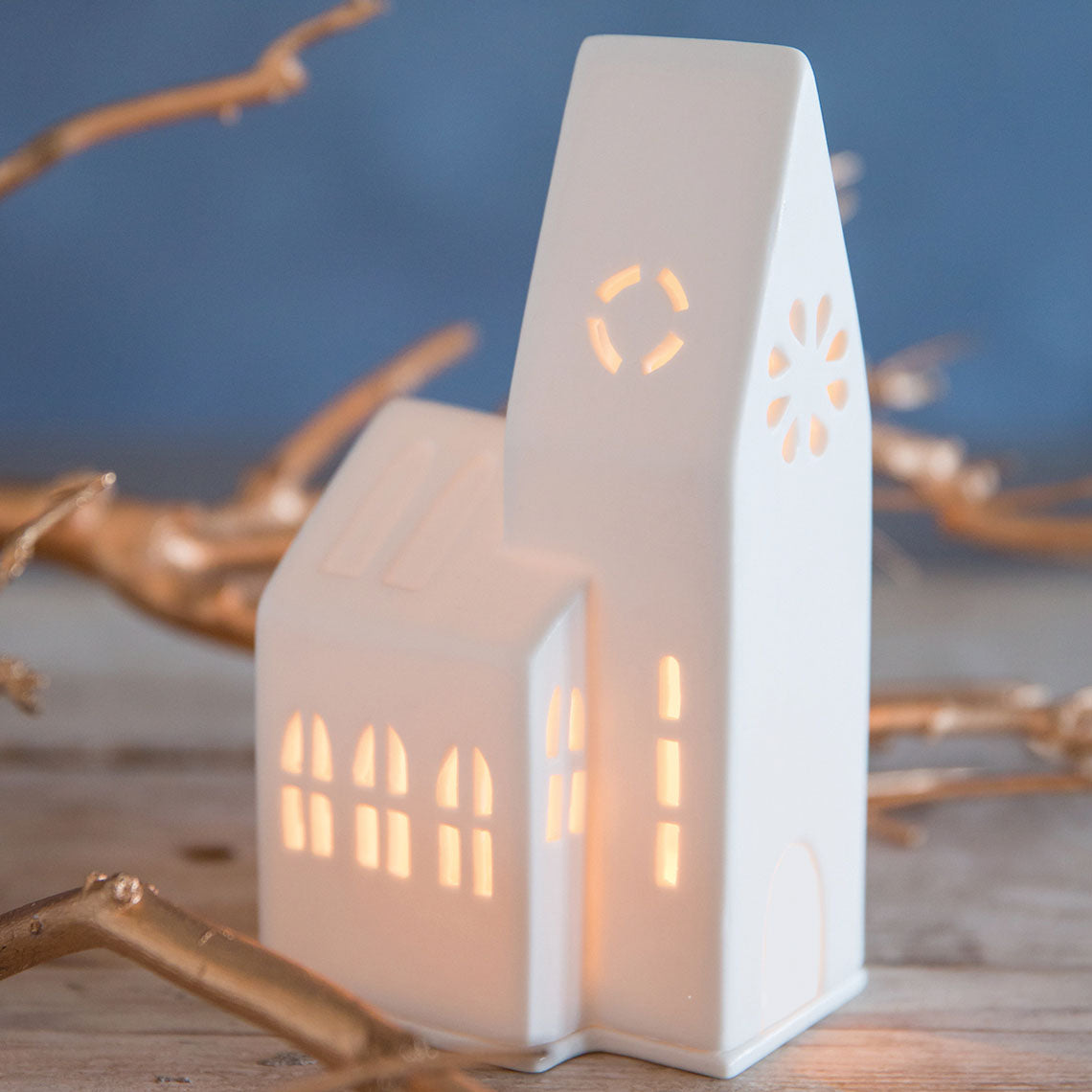 Photophore en porcelaine blanche en forme de petite église, vue de côté.