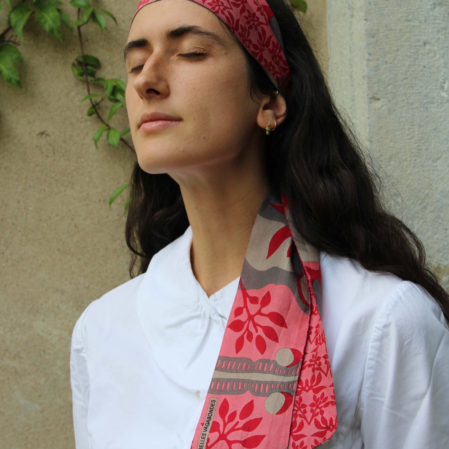 Bandeau en soie porté dans les cheveux. 