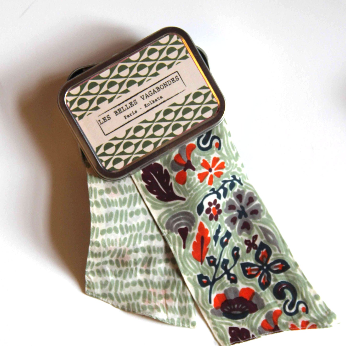 Bandeau en soie avec un motif floral et végétal, dans les tons vert kaki, gris, noir et orange vif. 