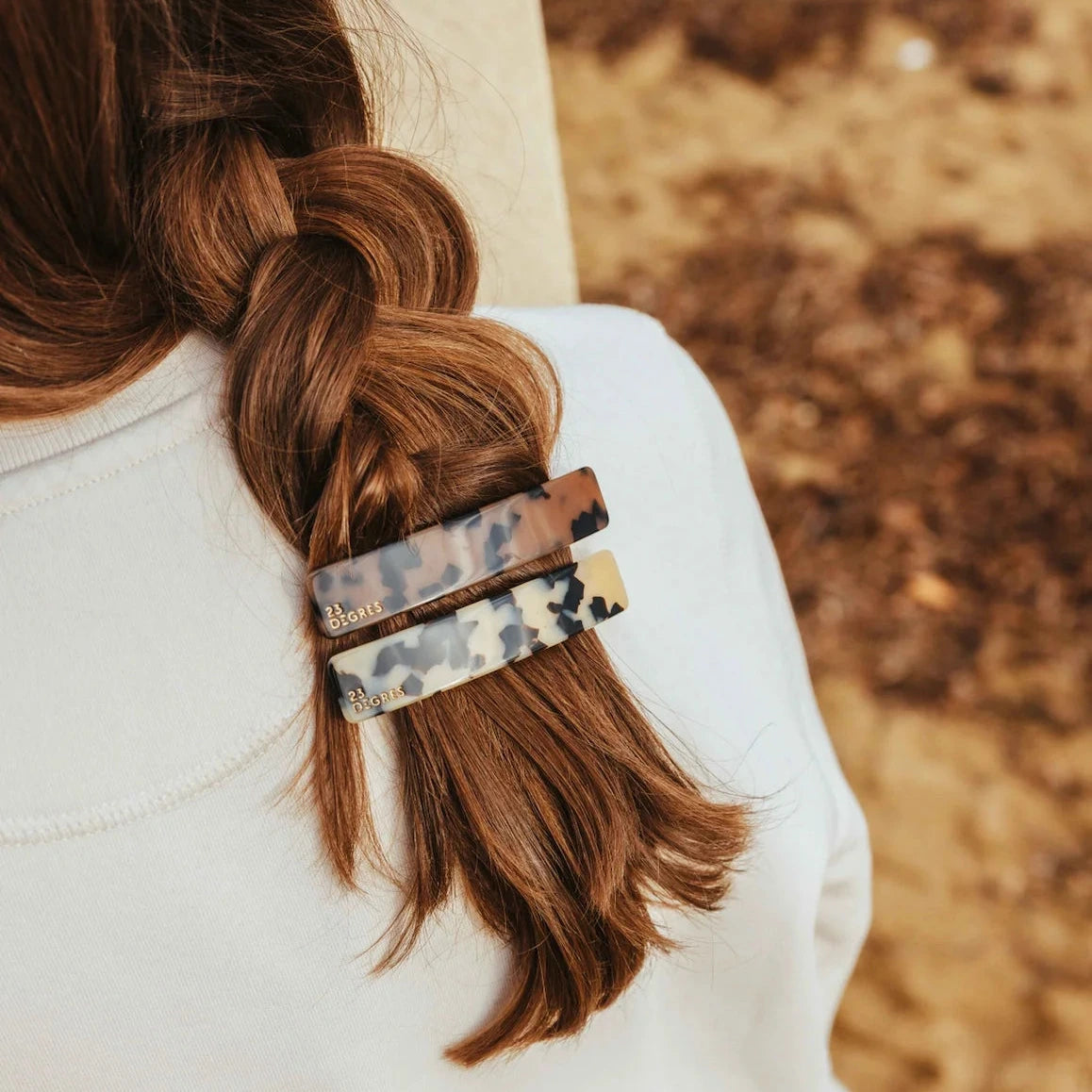 Femme portant une barrette 9 cm en tresse, coloris beige à motif léopard.