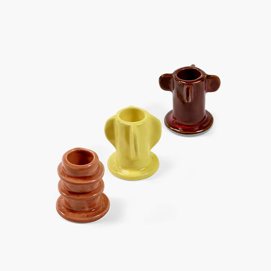 Trio de bougeoirs en grès émaillés, de forme organique et de couleurs orange, jaune et marron. 