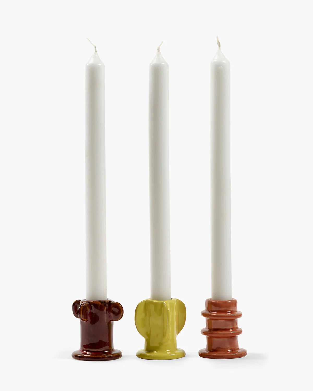 Trio de bougeoirs en grès émaillés, de forme organique et de couleurs orange, jaune et marron. 