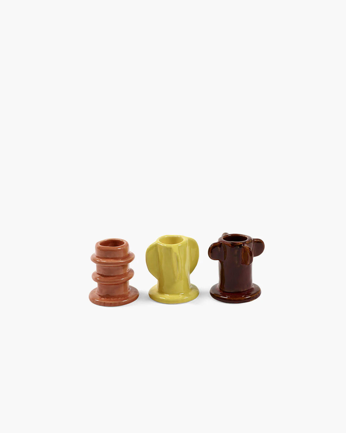 Trio de bougeoirs en grès émaillés, de forme organique et de couleurs orange, jaune et marron. 