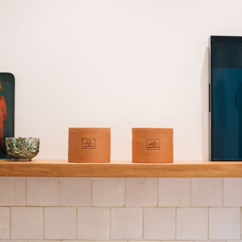 Moyenne bougie dans un contenant en poterie marocaine.