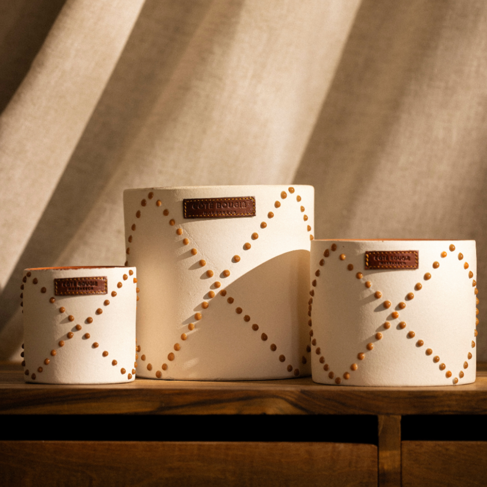 Moyenne bougie dans un contenant en poterie marocaine.