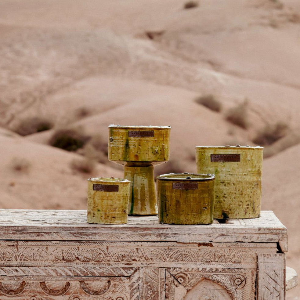 Bougies dans des contenants en poterie Tamegroute jaune.