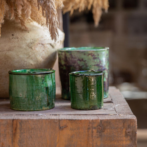 Bougies dans des contenants en poterie Tamegroute vert.