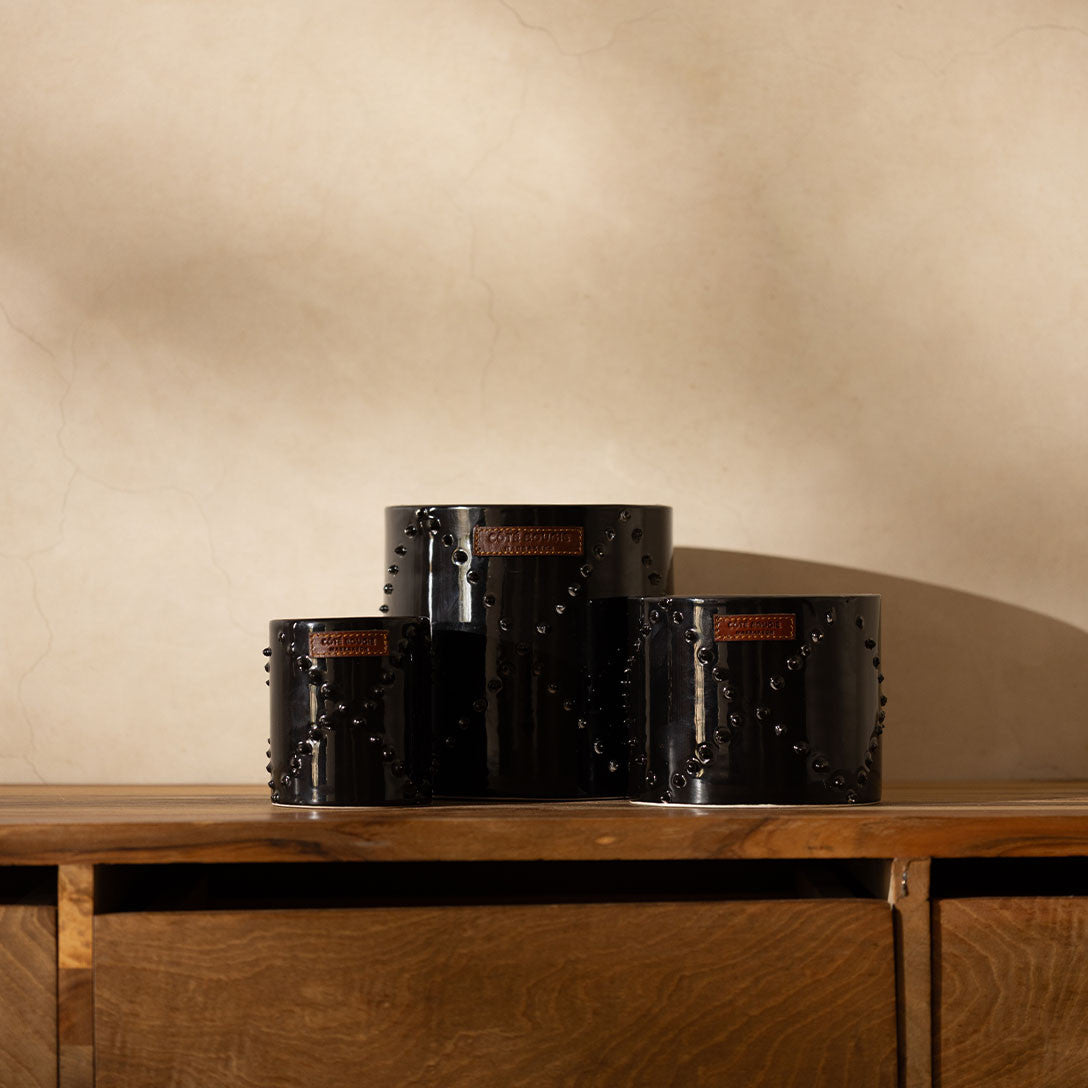 Bougies dans un contenant en céramique noir. 