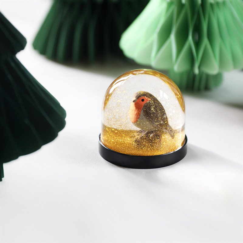 Boule à neige Klevring, avec un rouge-gorge sous des paillettes dorées.