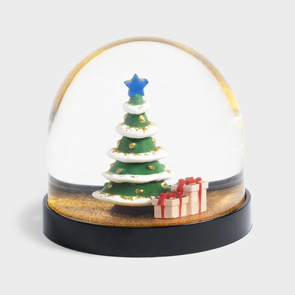 Boule à neige Klevring, avec un sapin de Noël et quelques cadeaux sous des paillettes dorées.