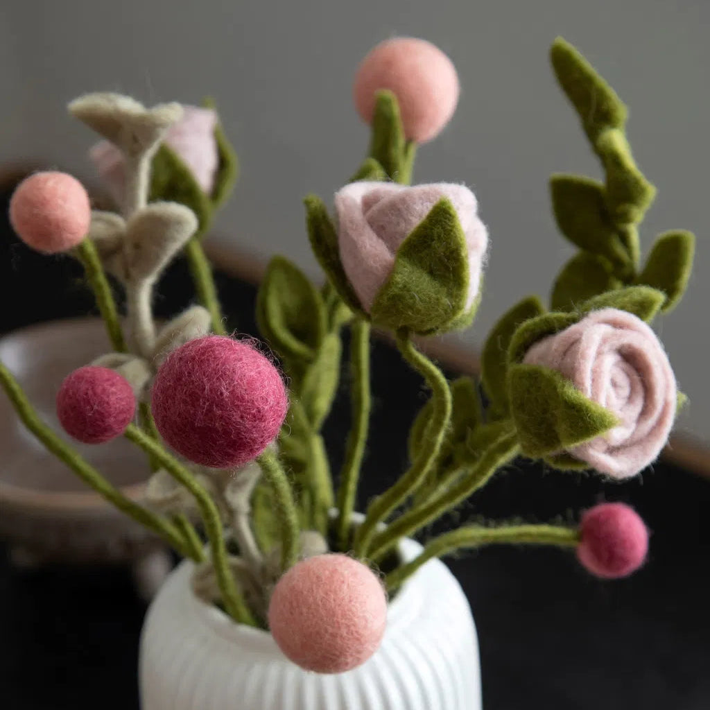 Zoom sur un bouquet de fleurs en laine feutrée dont des roses. 