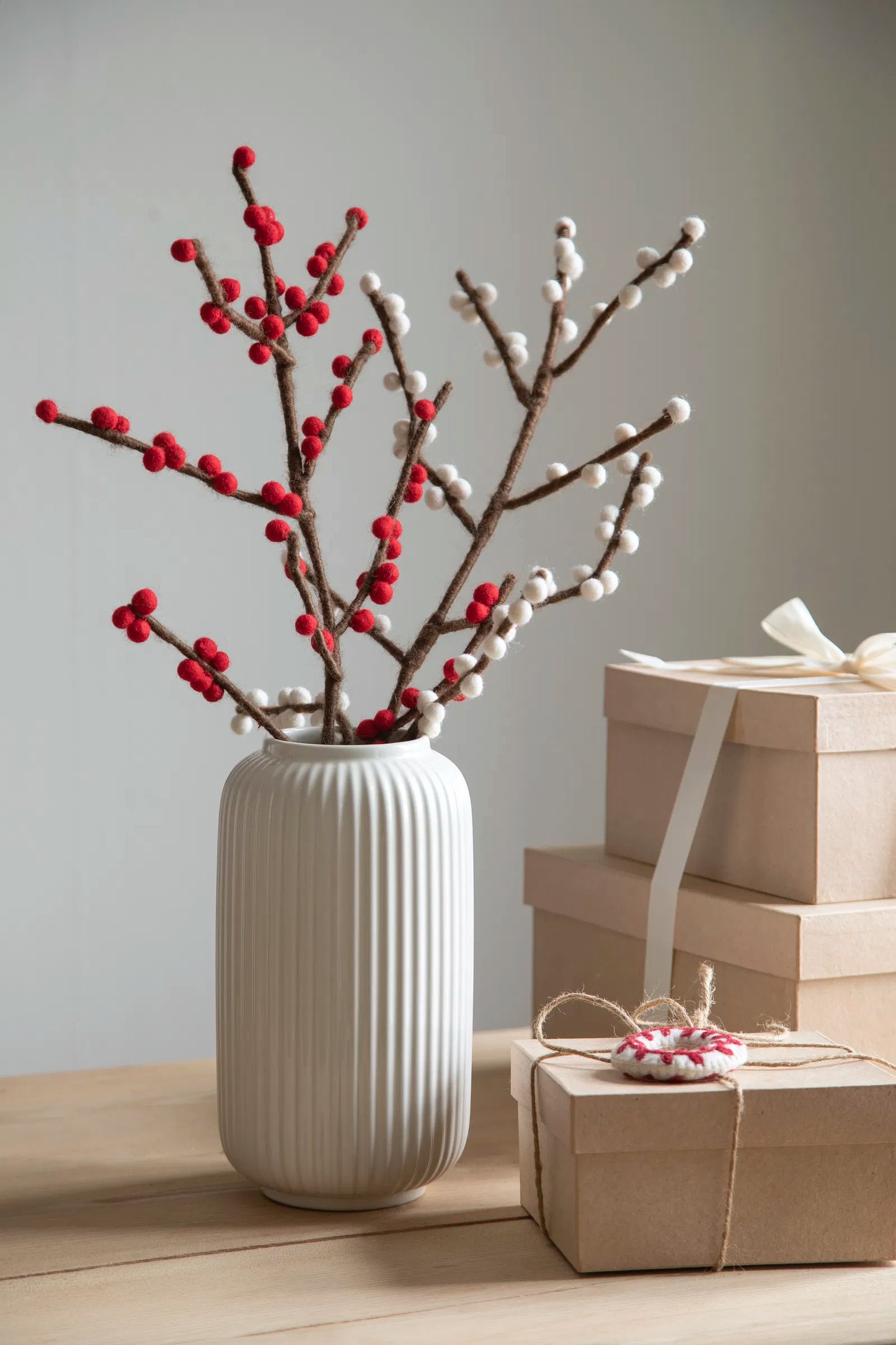 Branche avec des petites boules tels des bourgeons; dans un vase.