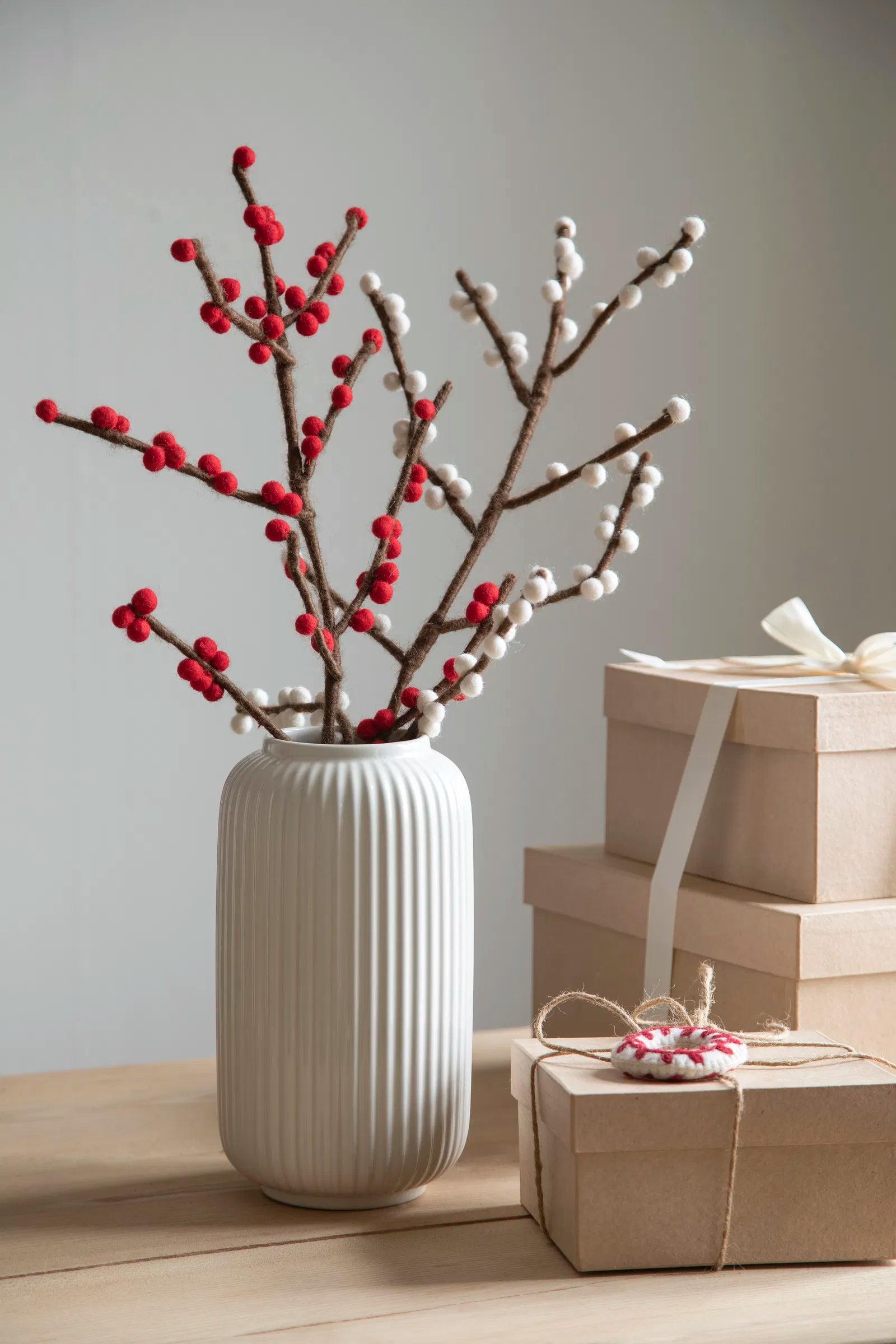 Branche avec des petites boules tels des bourgeons; dans un vase.