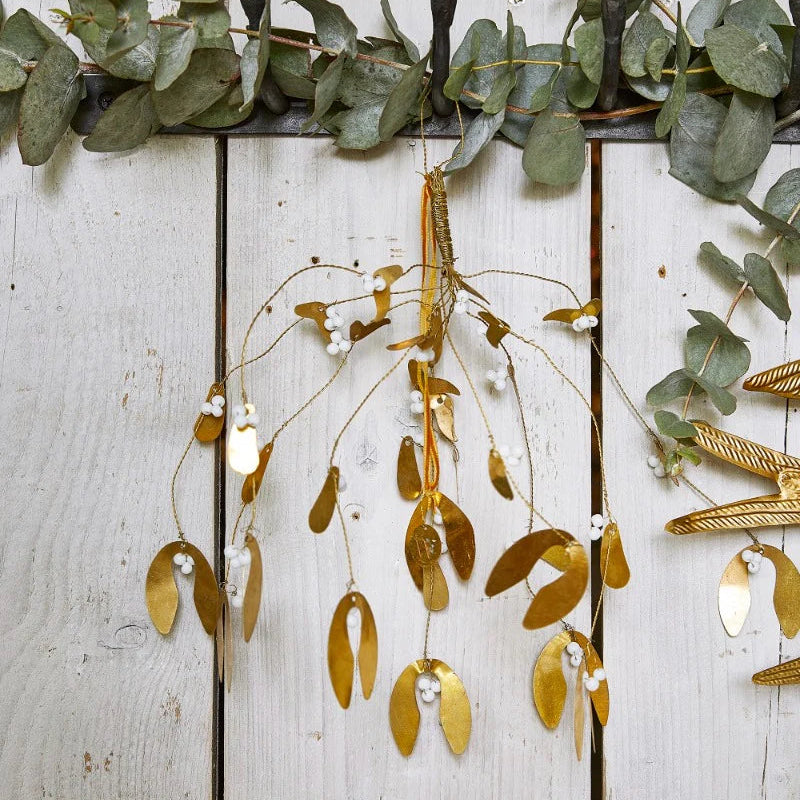 Branche de gui à suspendre en métal doré avec des petites perles blanches.