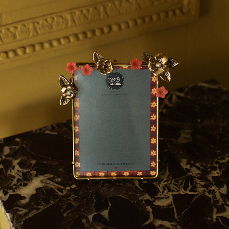 Cadre en laiton doré avec motifs de fleurs sauvages dorées et roses incrustées.