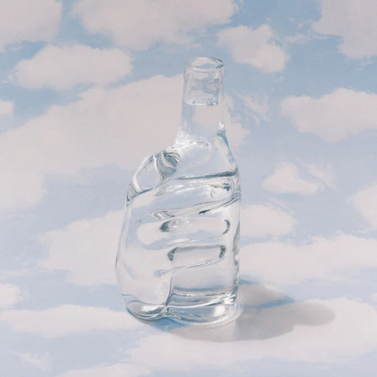 carafe en verre transparente avec une main en relief de serax