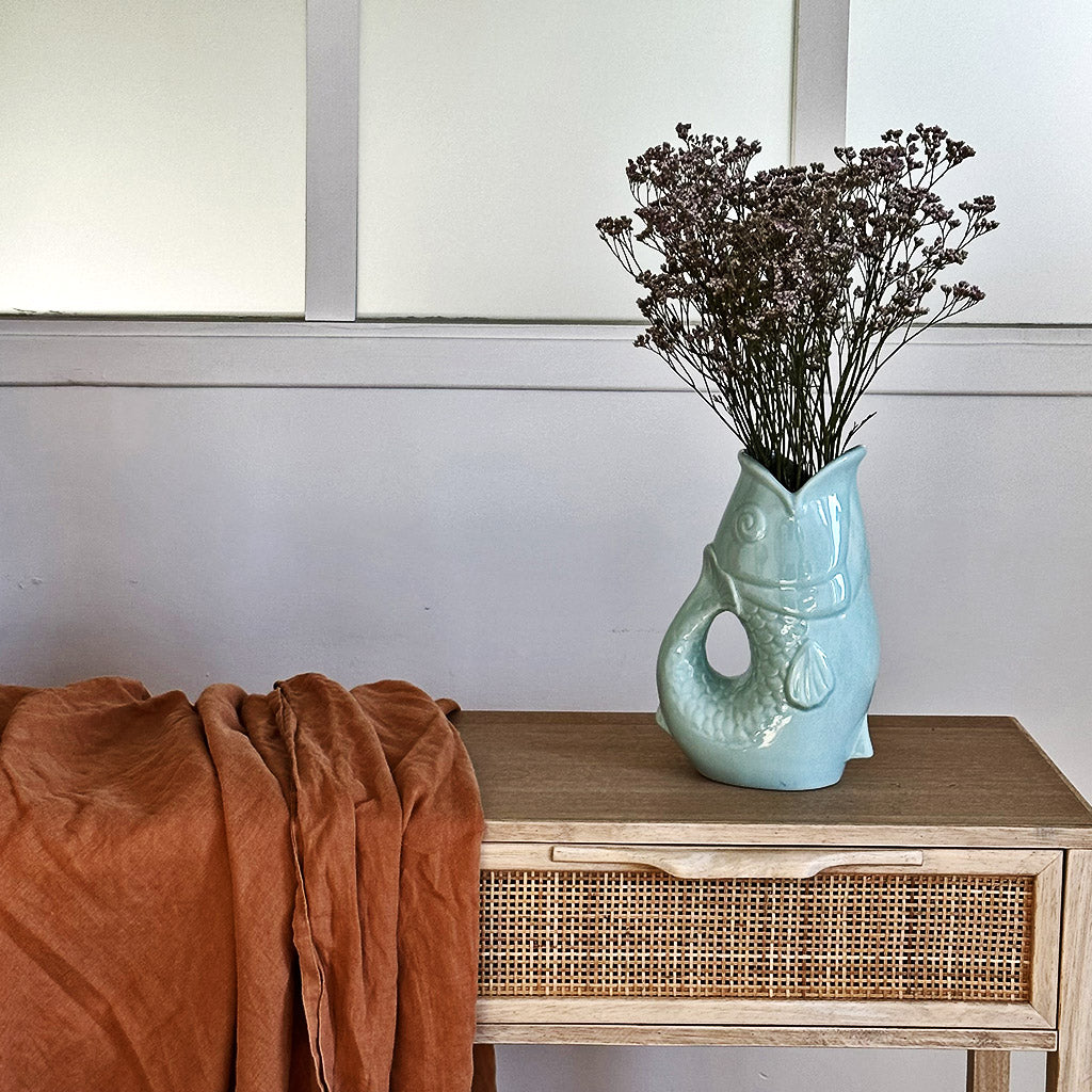 Carafe, vase ou pichet en forme de poisson en céramique bleu clair dans un décor assorti.