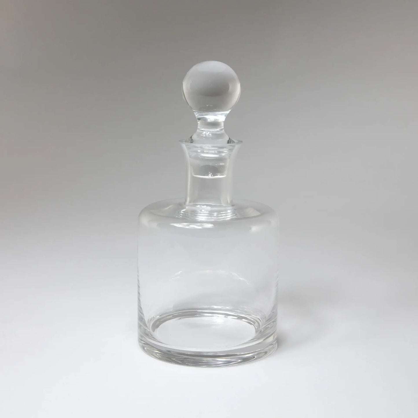 Carafe en verre cylindrique transparent avec bouchon rond. 