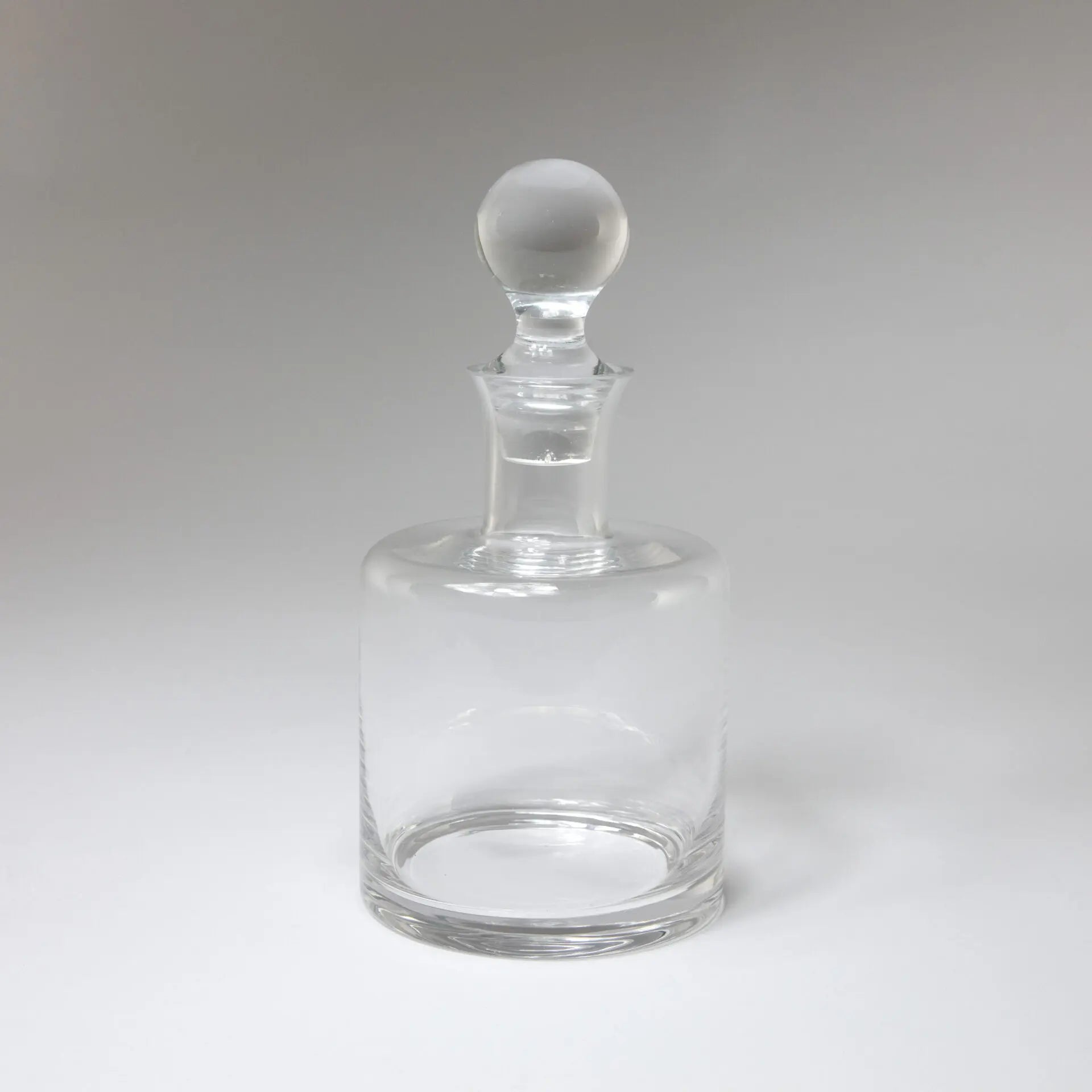 Carafe en verre cylindrique transparent avec bouchon rond. 