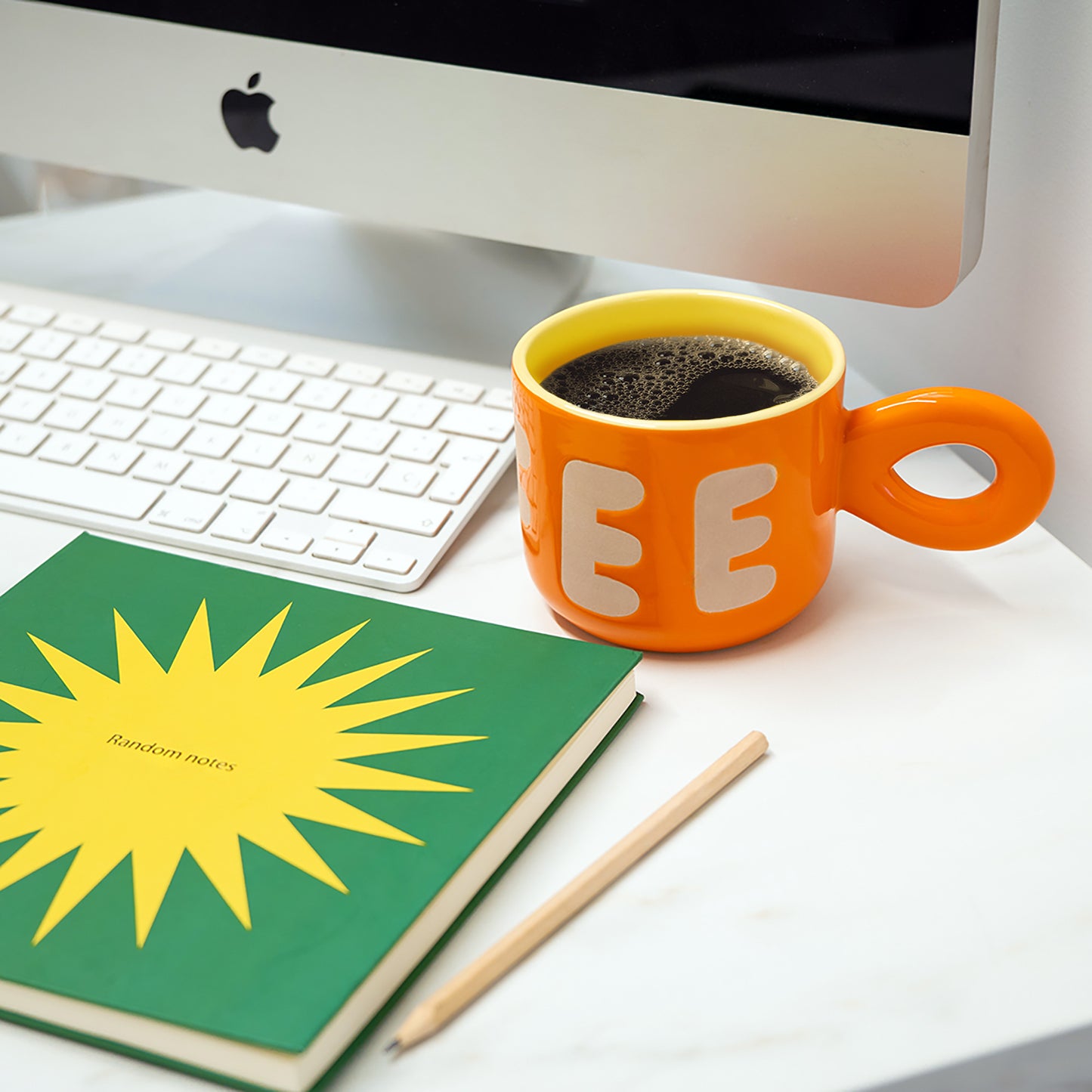 Carnet carré, couverture rigide verte avec soleil jaune. 