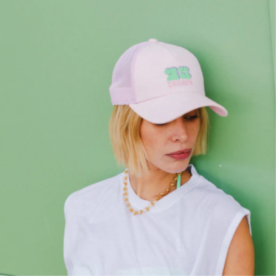Casquette rose modèle Sunshine avec logo brodé vert, forme trucker avec filet.