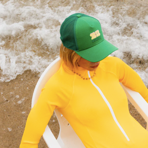 Casquette verte modèle Sunshine avec logo brodé jaune pâle, forme trucker avec filet.