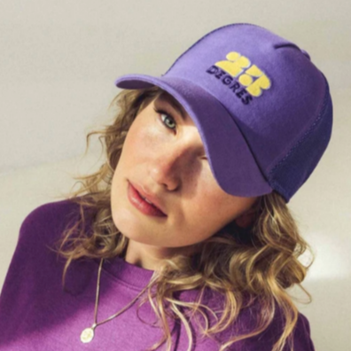 Casquette violette modèle Sunshine avec logo brodé jaune, forme trucker avec filet.