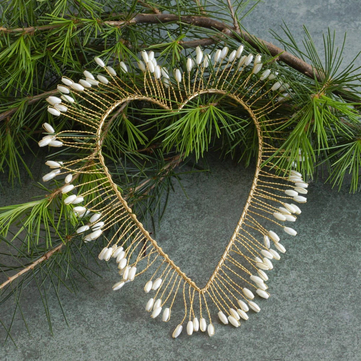 Coeur auréolé en fils dorés et perles blanches, à suspendre en décoration de Noël.