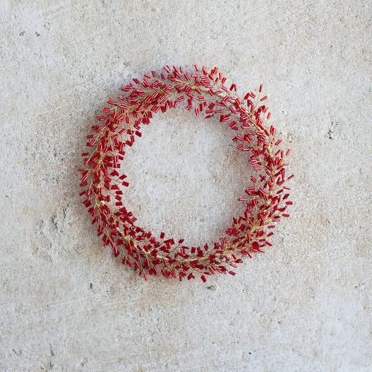 Couronne de perles rouges à suspendre ou à poser comme décoration de Noël.