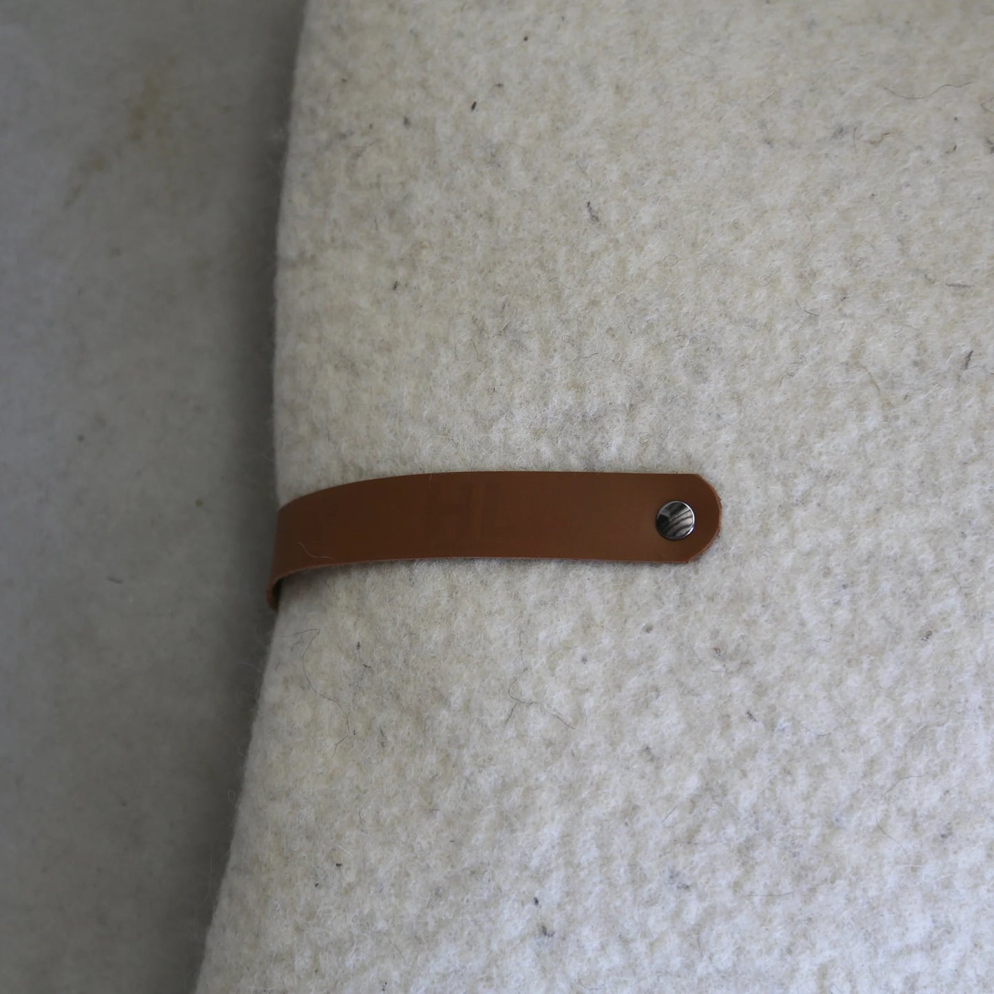 Coussin en laine feutrée ivoire française avec un lien en cuir. 