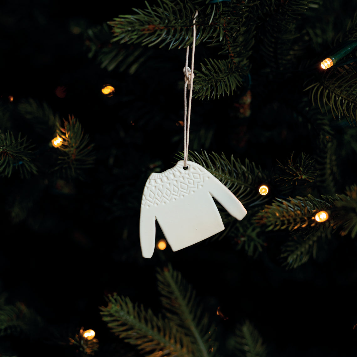 Décoration de Noël à suspendre en forme de pull-over en porcelaine blanche. 