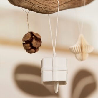 Cloche en porcelaine à suspendre en forme de cadeau, mise en scène.