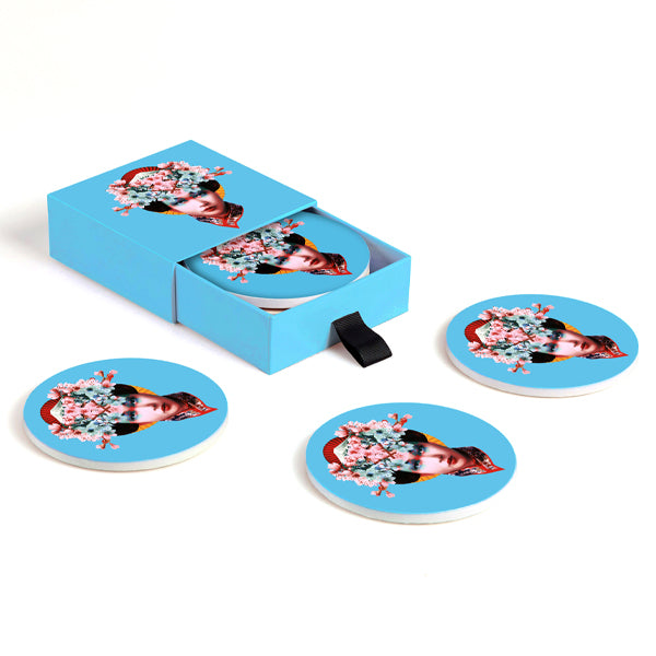 Dessous-de-verre en céramique dans leur boîte de rangement, modèle Miss Fuji, fond bleu. 