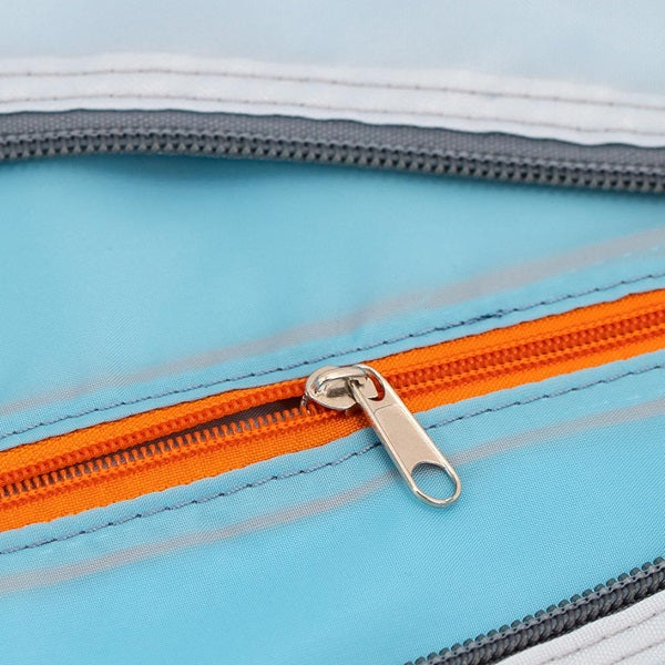 Détail de la fermeture éclair orange du sac bleu.