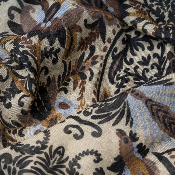 Détail de l'écharpe en laine et modal, à motif d'arabesques, dans les tons crèmes.