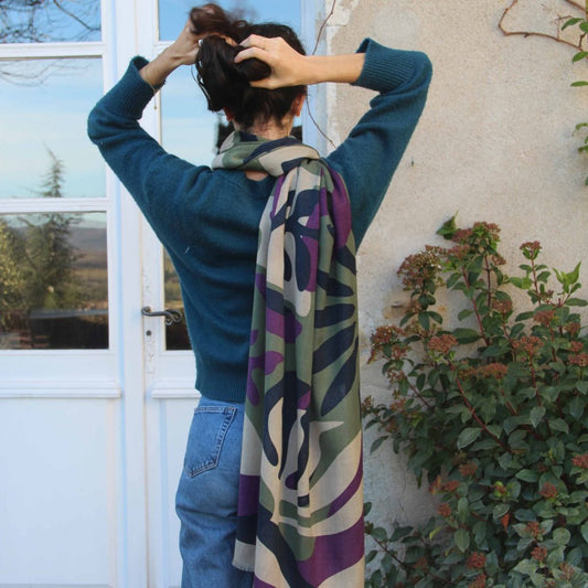 Echarpe en laine portée de dos avec le dessin Fidji kaki, un motif végétal dans les tons vert kaki, violet, bleu marine et écru.