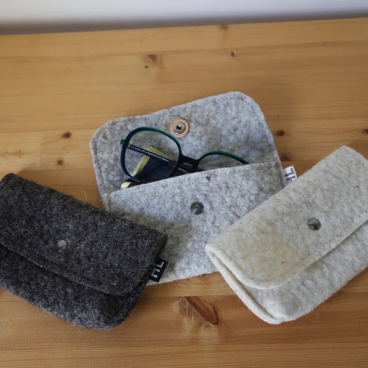 Pochettes de rangement ou étuis à lunettes en laine feutrée française, coloris ivoire ou gris.