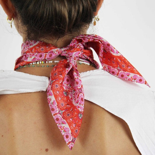 Foulard carré en soie, porté autour du cou, modèle Agadir rose. 