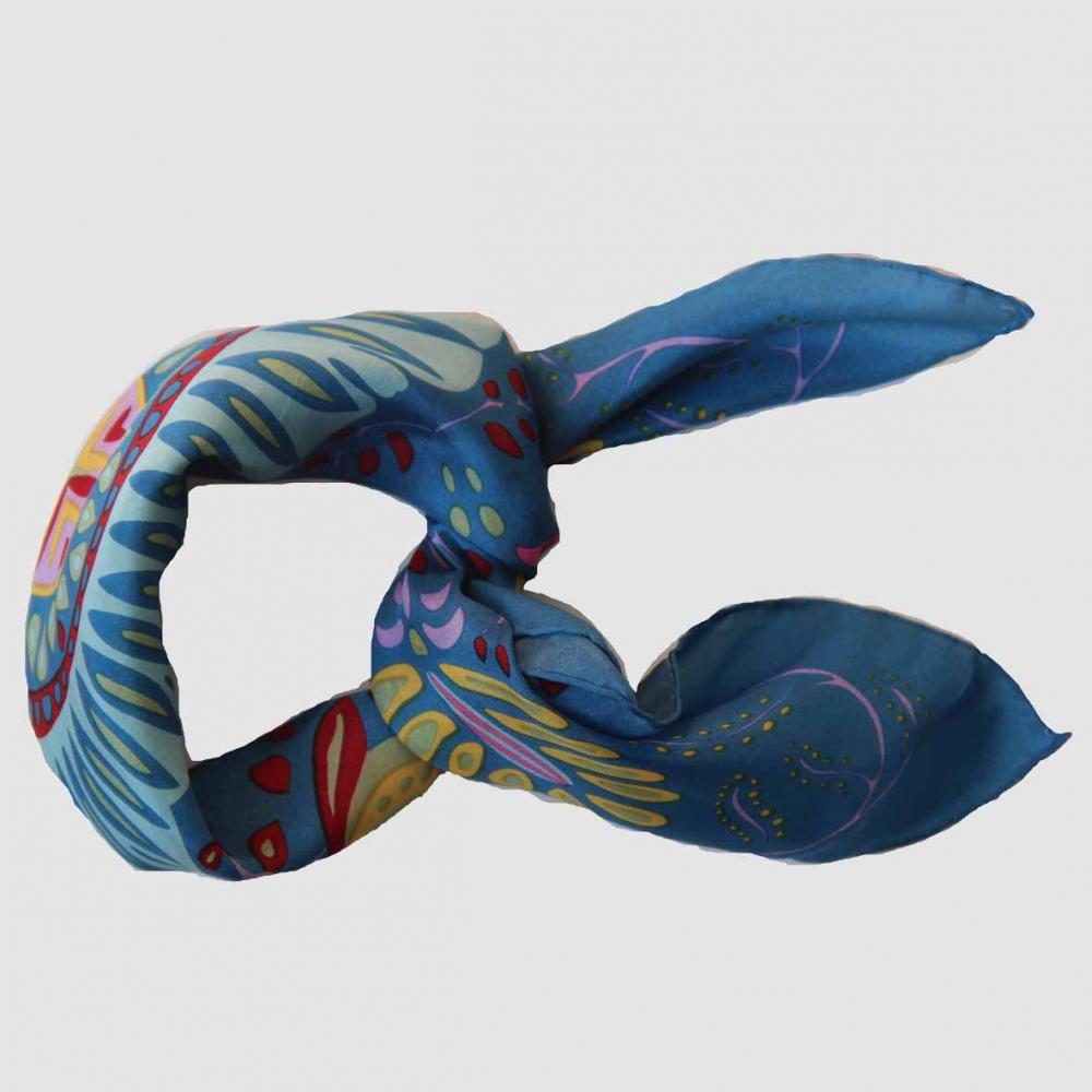 Foulard carré en soie avec motif floral comme un mandala, dans les tons bleu, jaune, rose et rouge.